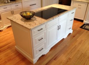 This island was made deeper, front to back to allow room for a popup, downdraft vent. Note furniture base at bottom of cabinet. PO trays behind doors for pot and pan storage. Ends are panelized.