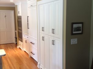 The bi-fold doors and wire shelving were discarded and we built a slide in unit with cabinet doors. Roll outs behind the doors provide deep accessible storage. The microwave was place inside behind the doors.