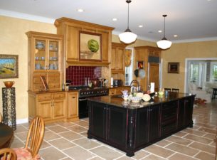 This kitchen was remodeled  by removing walls to create a large common space which serves as kitchen, casual dining and display. There are 4 separate styles and finishes on the cabinetry in this project.