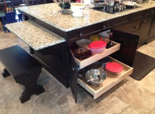 Here you can see the 2 roll out trays in the bottom section of the island base cabinet. Roll out trays make access to stored items infinitely easier than shelves. Note the shop made bench seat which resembles the corbels.
