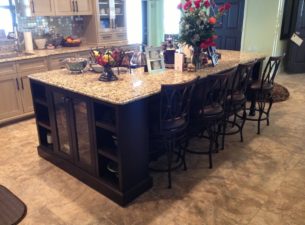 The back side of the island is recessed, providing a space for chairs or stools and seating. The far end has a lowered section of granite top which provides for kids to eat at the island as well.