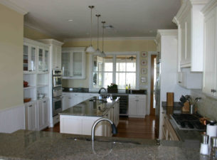 Another Picture of this wonderful Custom farmhouse kitchen. Simple yet some sophistication is present with the complexity of the moldings. White Conversion Varnish with a subtle Stonedust Glaze. Note the varying sectioning of the cabinetry.