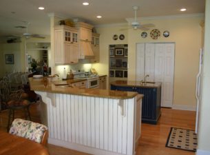 An important aspect of kitchen design is the selection of materials, since it affects the blend of color and texture as well. These wood cabinets are painted and contrast the stain finish of the floors. Granite completes the palate.