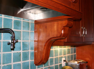 A close up shot of the bottom of the Range hood in which you can see the corbel made from solid cherry and the custom fabricated stainless steel hoodliner which was used on this project.