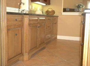 In this photo you can see the detail of the angled flutes with furniture base @ the sink. What appears to be a drawer stack to the right of the sink is actually a Dishwasher that has had false panels applied to the front preserving the cabinet look