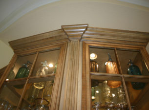 Notice the shelves are actually wood frames with glass set into them. This cabinet was made from a template of the alcove shape so as to fit into an irregularly shaped space. Notice the crown detail on the fluting!