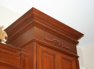 The combining of various molding profiles and onlays can provide a distinctive unique look to custom cabinetry. The cherry material utilized for this job provides a deep rich color for the piece.