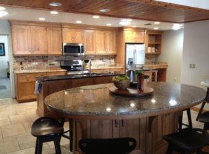 This kitchen is made with Knotty Alder. The gathering island was made with a large oval granite top. The base was made as a hexagon and has inset doors and a furniture base.