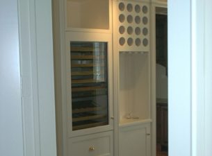 The sub zero wine cabinet has been seamlessly integrated into this elevation. The round openings for wine bottle display and storage are above an area specifically designed to hold an unique wine bottle opener.