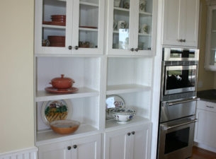 This is an example of special sectioning of cabinets. The cabinets to the left have been reduced in depth and then held off the wall. A TV in the room behind the cabinets is recessed through the wall behind the cabinets seen here.
